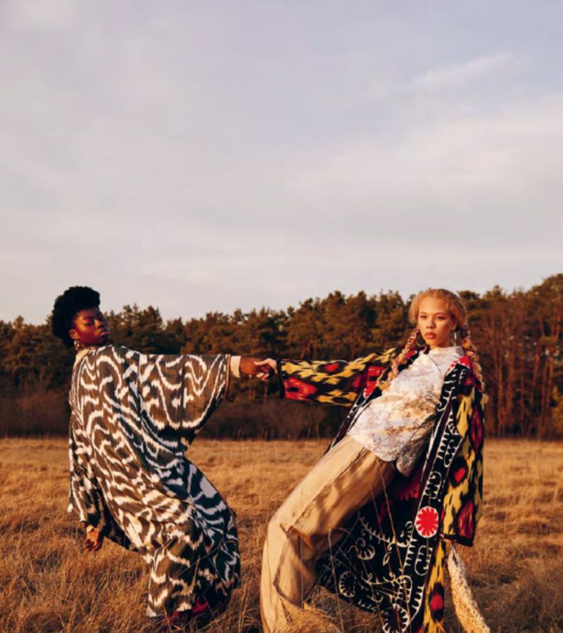 Person mit farbigem Kurzhaar und markanten Ohrringen in selbstbewusster, direkter Pose